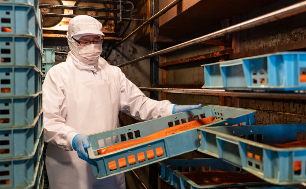 半世紀以上使い続けてきた燻製窯で燻製を仕込む職人の様子